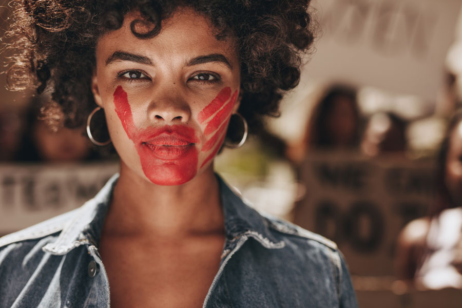 Image of a woman with a red handprint over her face.