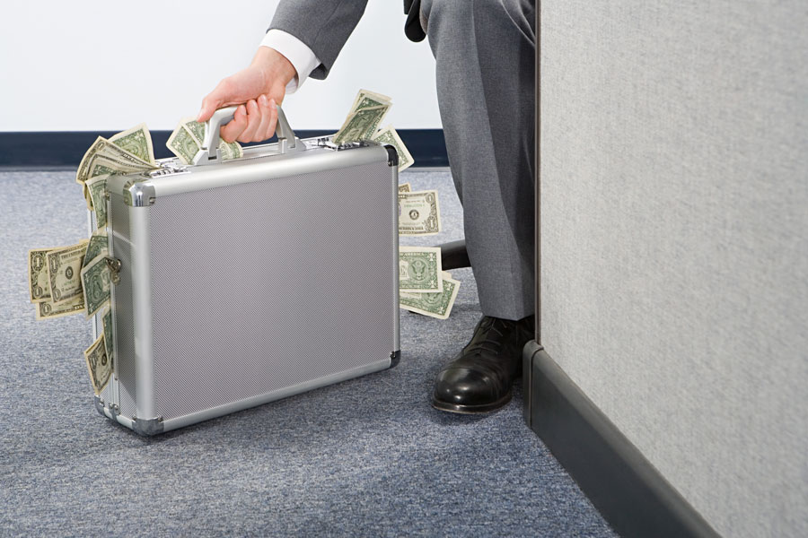 man in suit with suitcase full of money