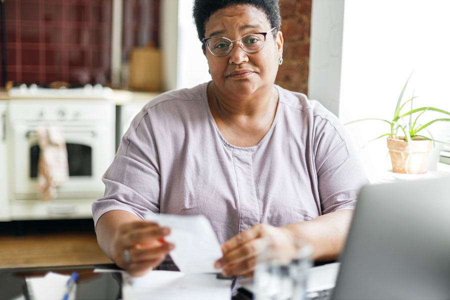 Woman looking at pay stub total with a questionable look on her face.